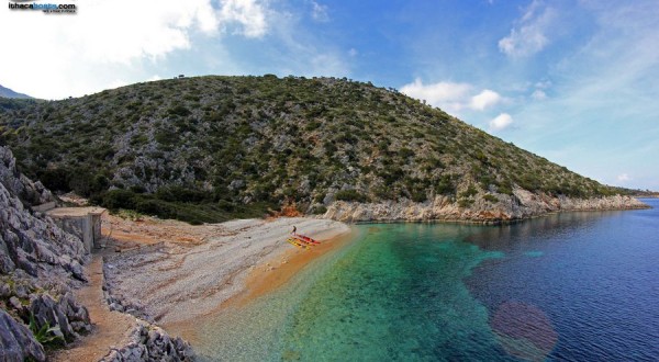 Photo of beach with rocks on Greek Ionian island with boats