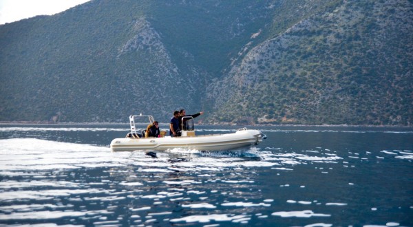 Sailing boat with two men and a woman on blue sea near Ithaca island